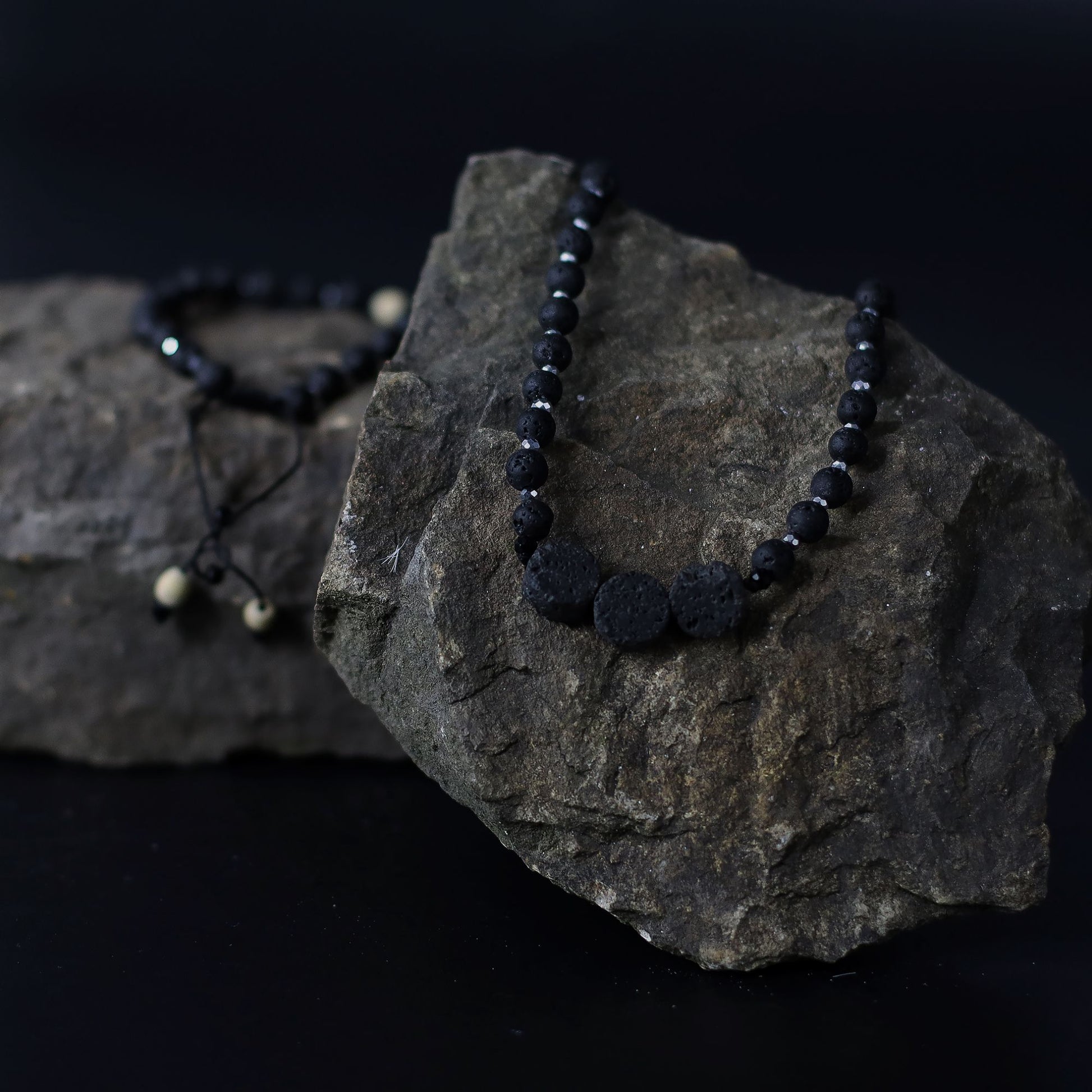 Essence of the Volcano Necklace on a dark rock with a black background