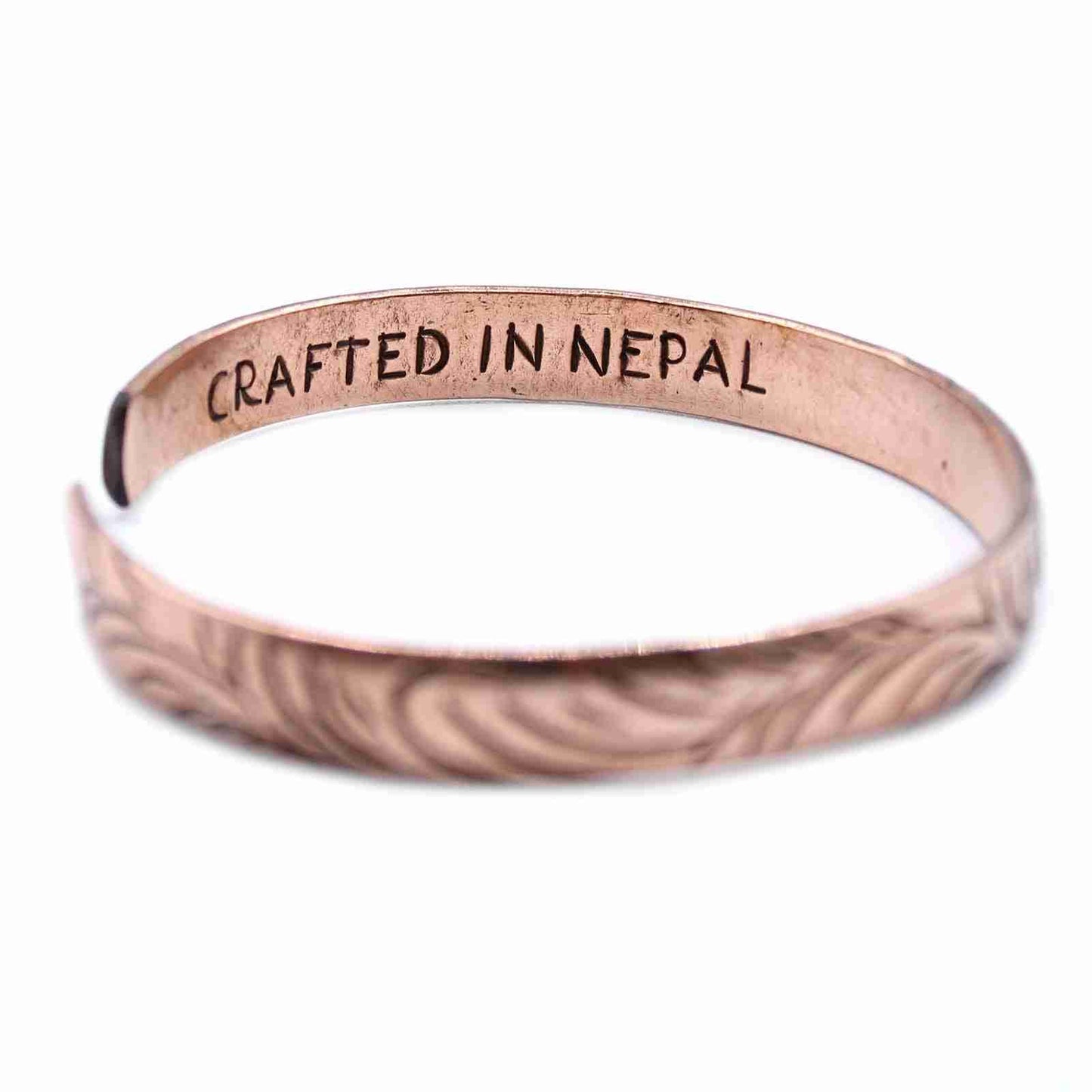 Copper Tibetan Bracelet - Slim Tribal  Swirls with 'CRAFTED IN NEPAL' engraving on a white background
