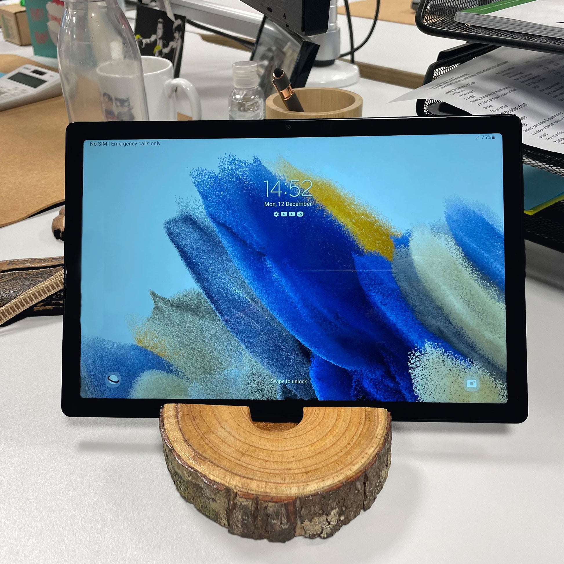 Tablet on a wooden stand with a colorful display on a desk