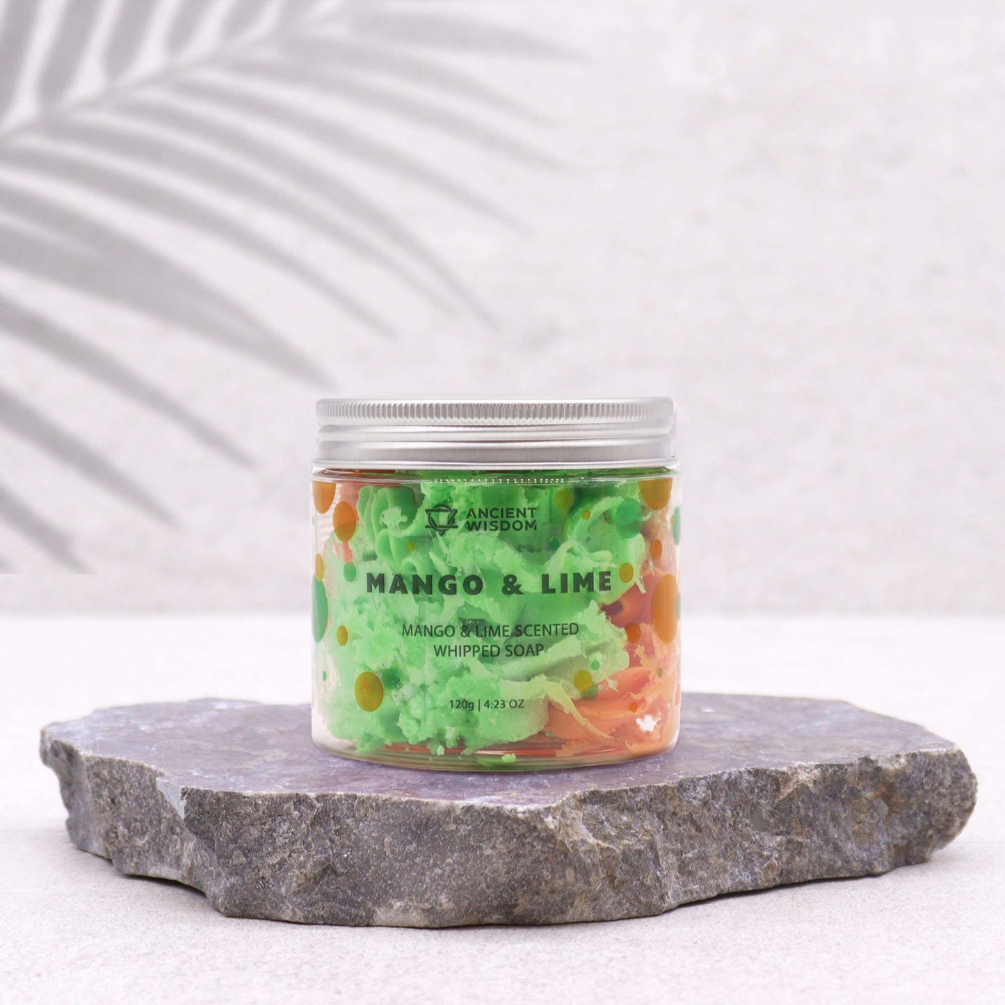 Jar of Mango & Lime scented whipped soap on a stone surface with a white background