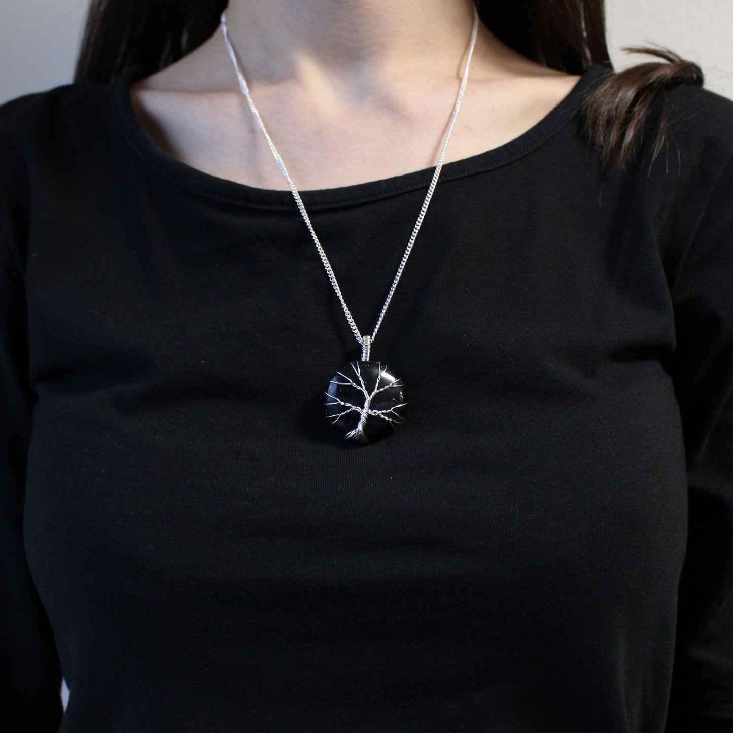 Person wearing a black shirt with Tree of Life Gemstone Necklace - Black Onyx