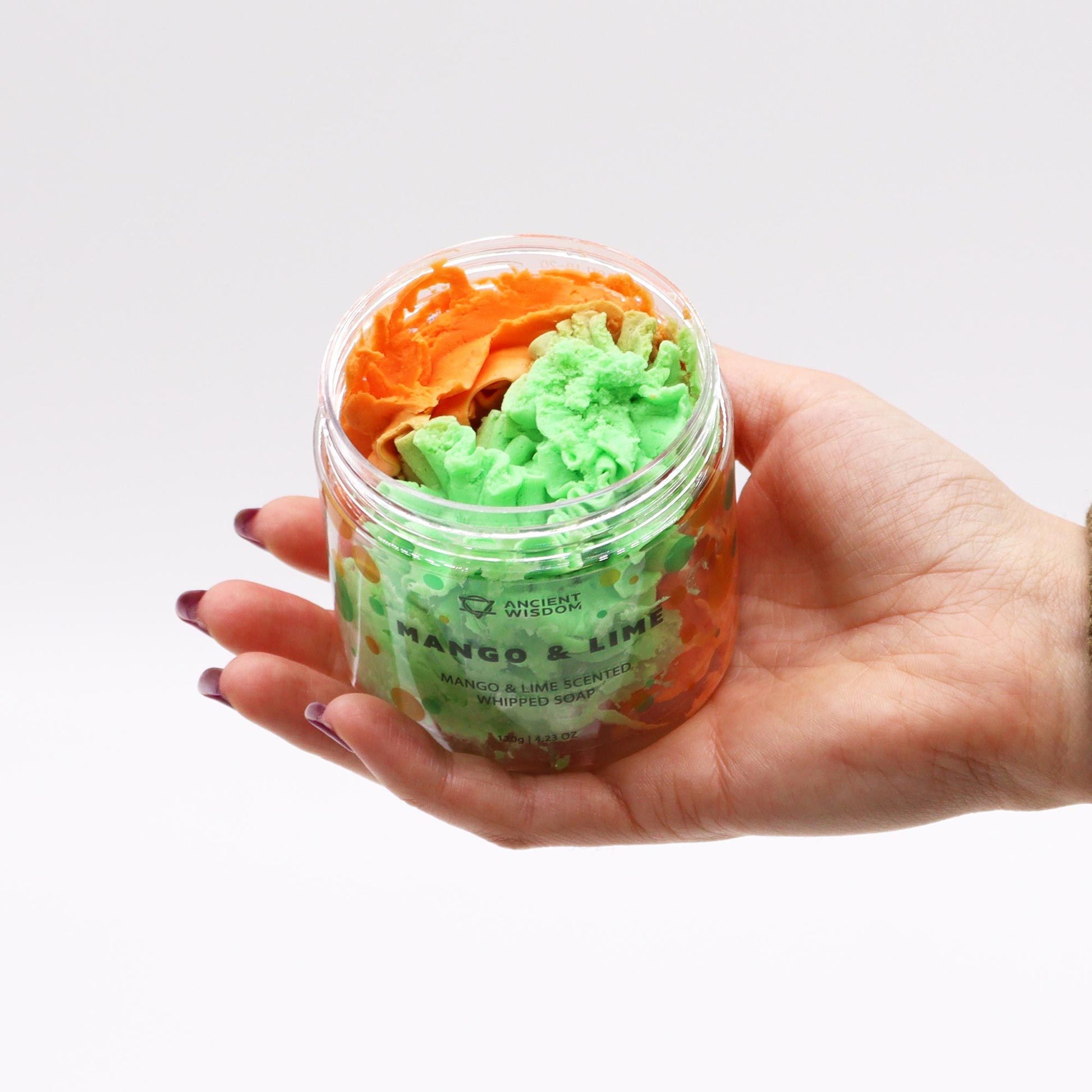 Hand holding a container of Mango & Lime Whipped Soap 120g