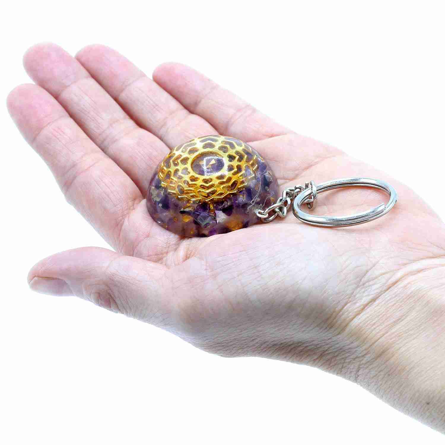 Hand holding a Orgonite Power Keyring - Amethyst Mandala Hearts on a white background