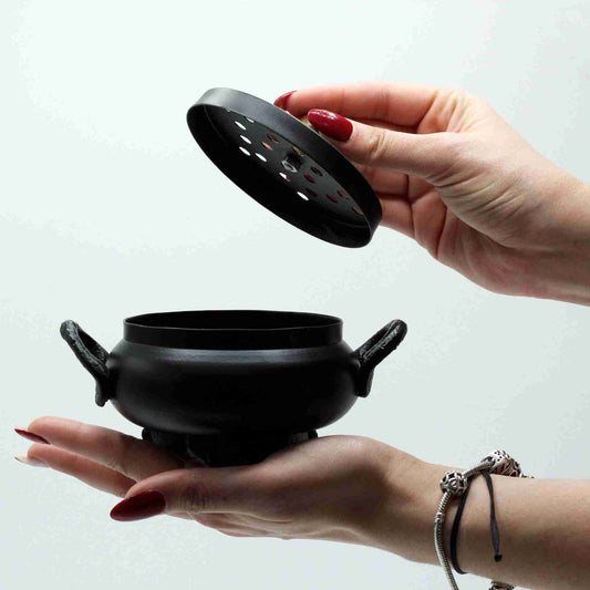 Classic Iron Cauldron Incense Burner held in a hand with a white background