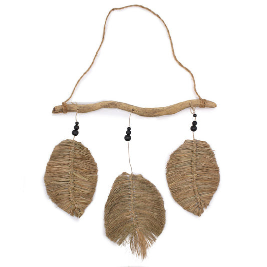 Decorative hanging with raffia leaf pendants on a branch against a white background