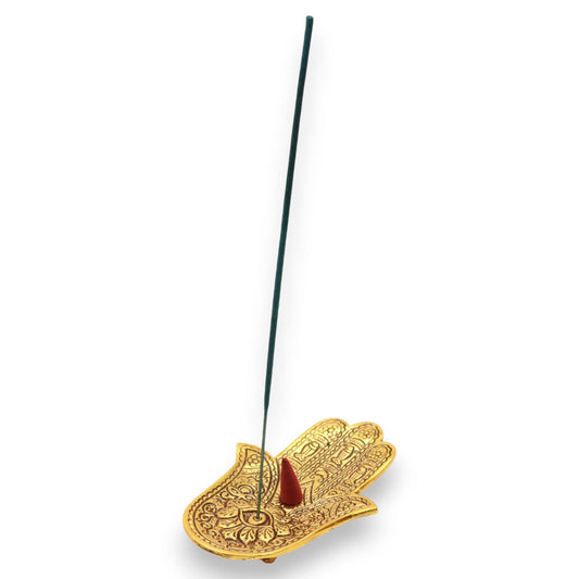 Gold Hamsa hand incense holder with a single incense stick on a white background