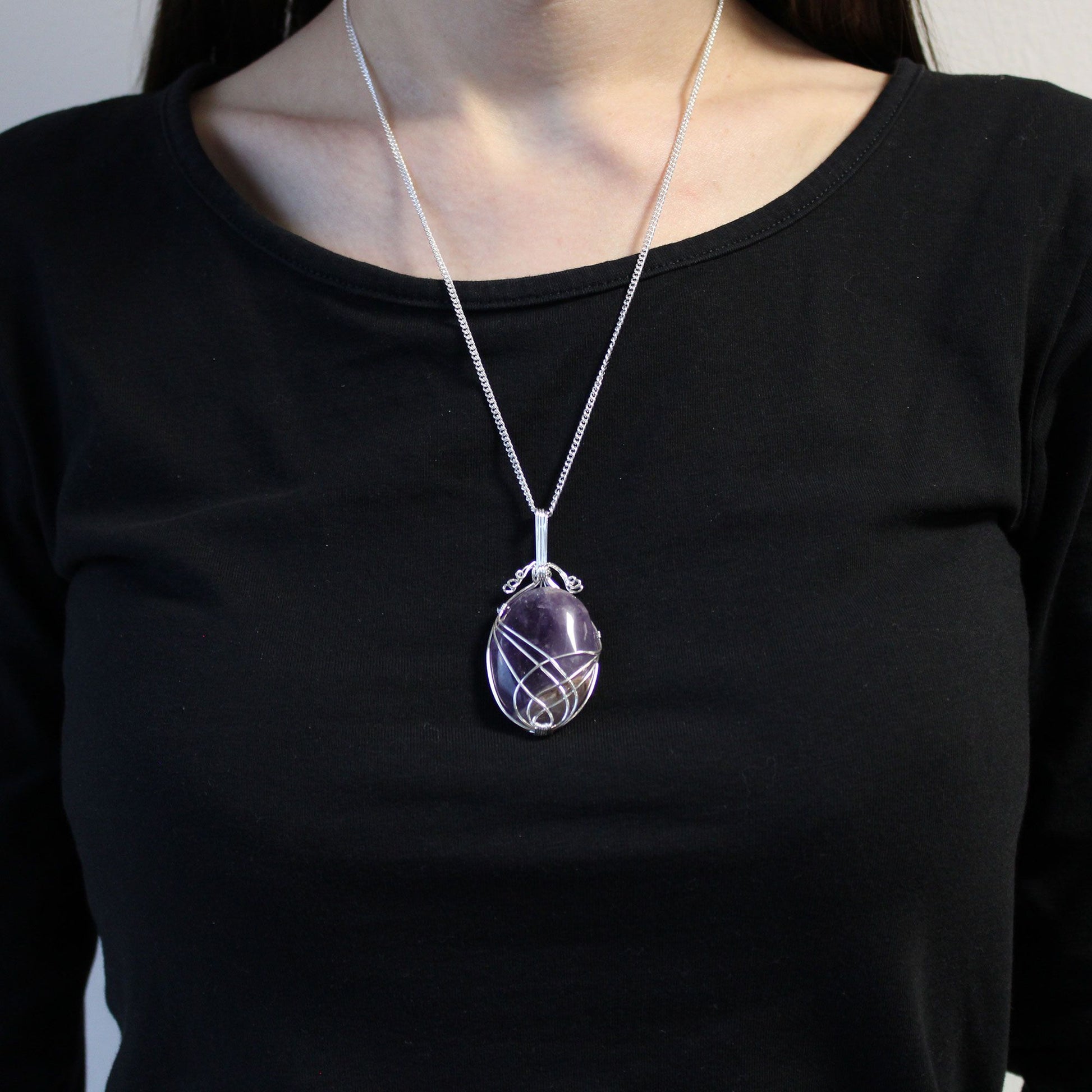 Person wearing a black shirt with Swirl Wrapped Gemstone Necklace - Amethyst