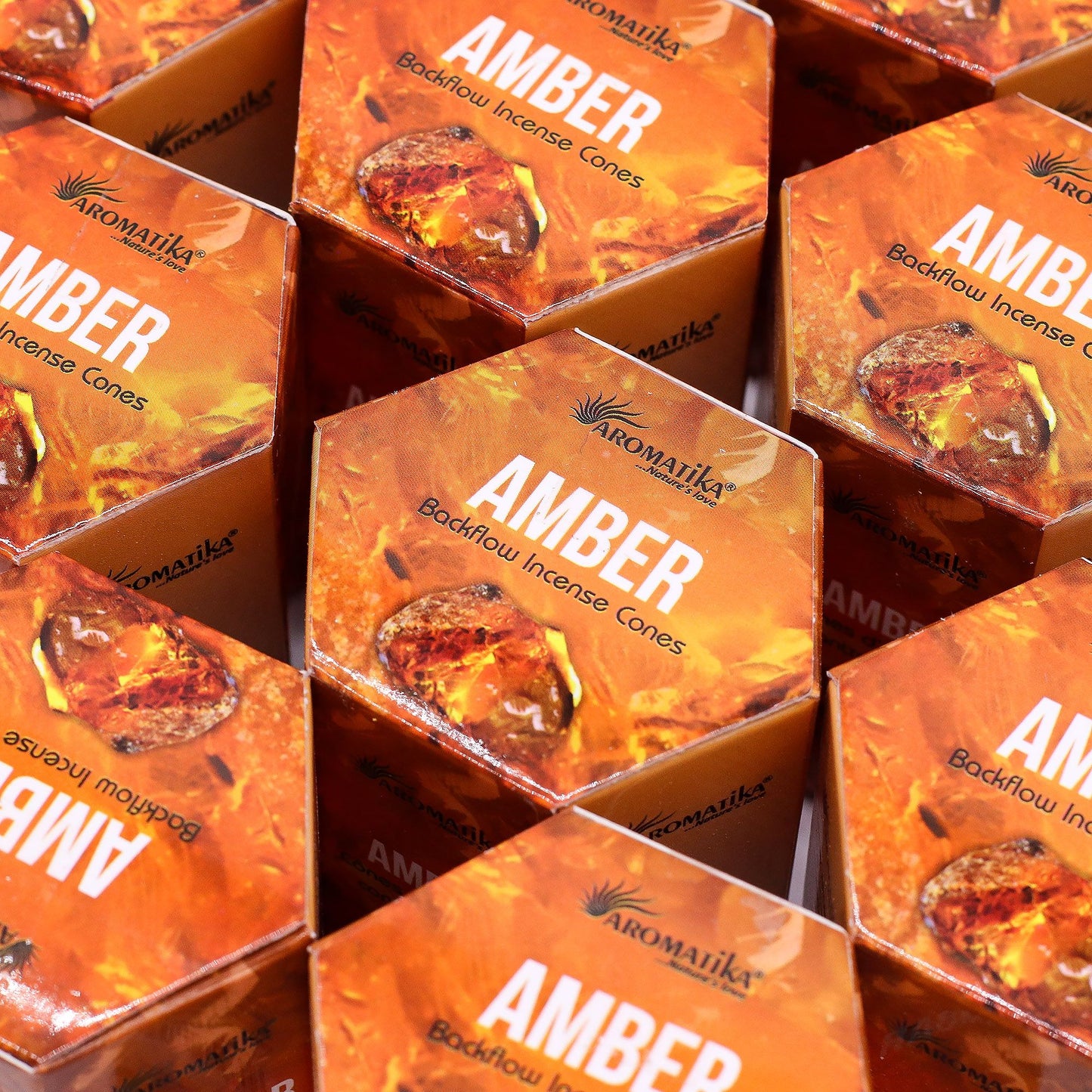 Multiple boxes of Aromatika Amber backflow incense cones arranged in a pattern.