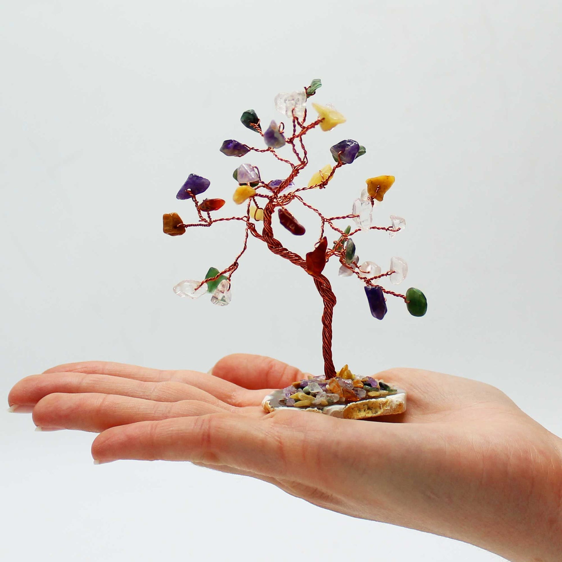 Small crystal tree on a hand against a white background