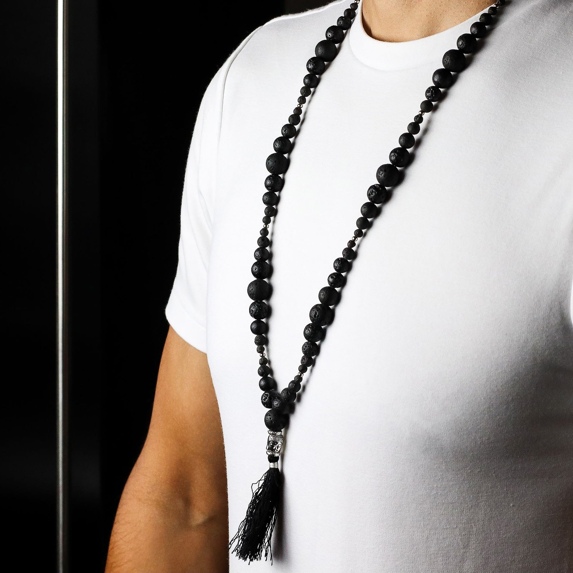 Person wearing a Essence of the Volcano Necklace with a tassel on a white background