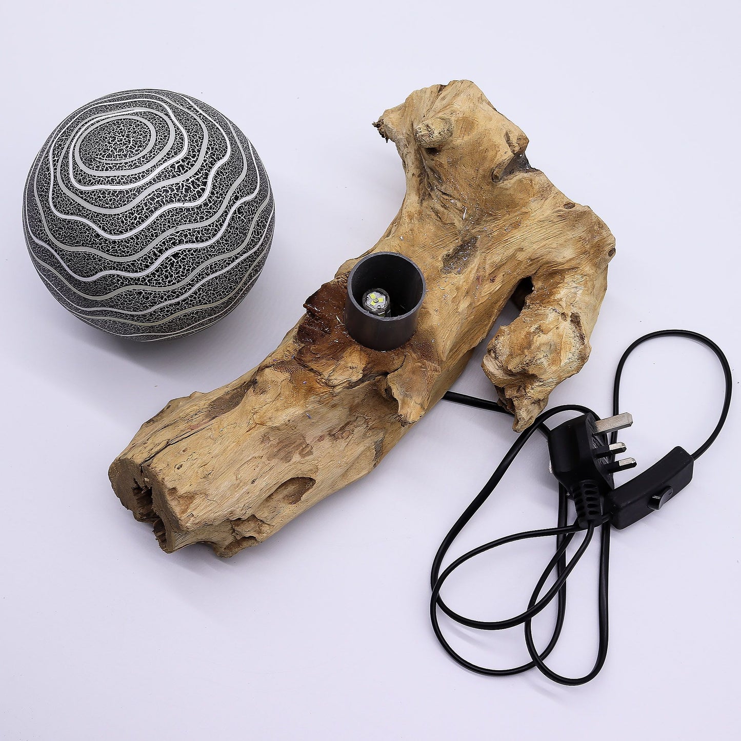 Driftwood with a lamp and power cord on a white background