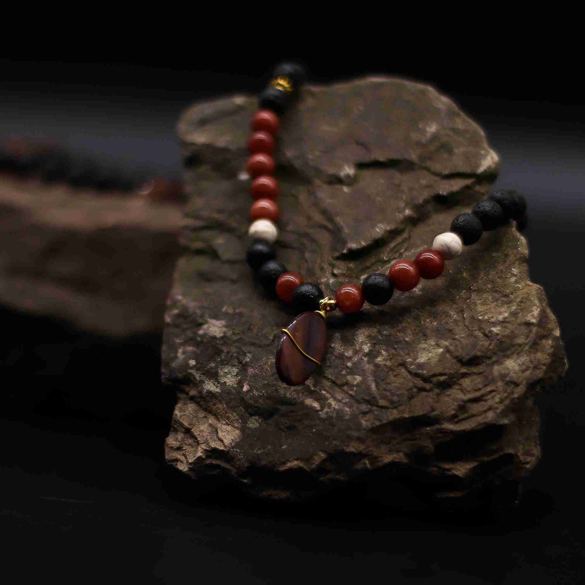 Essence of the Volcano Necklace - Protection close up displayed on a rock