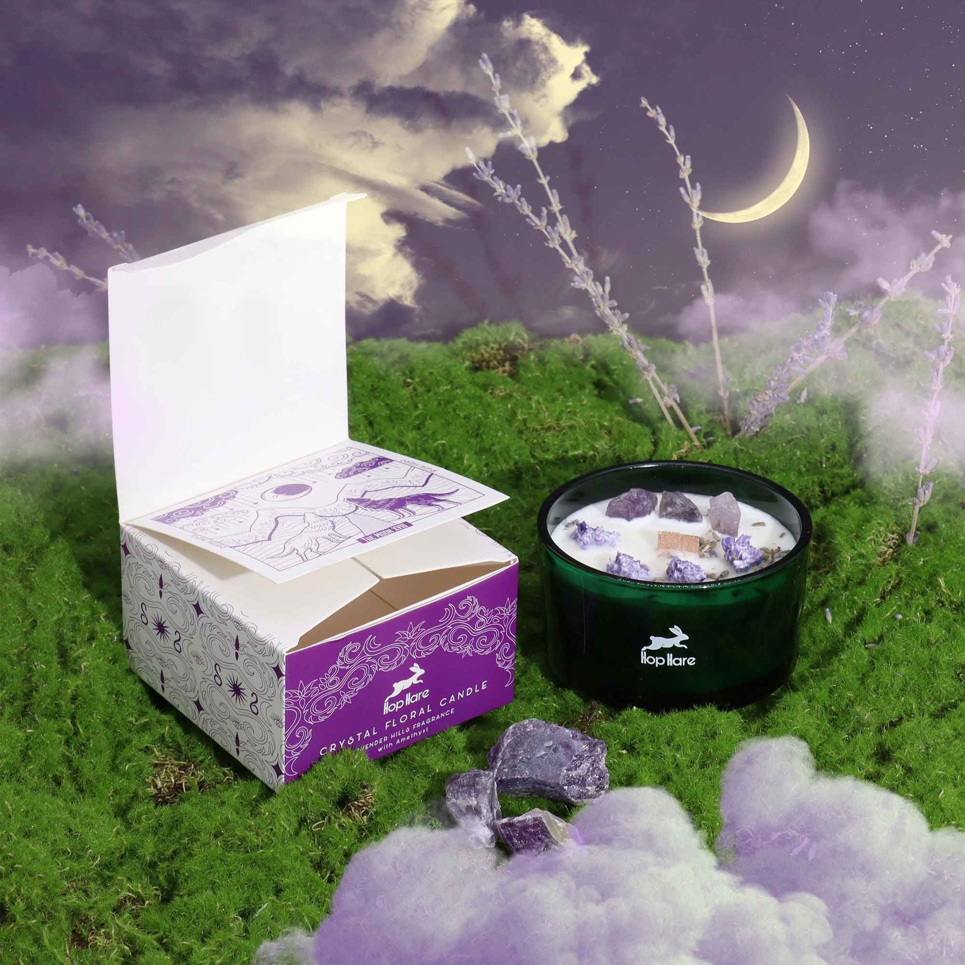 Hop Hare Crystal Magic Flower Candle - The Moon with packaging on a grassy field under a moonlit sky