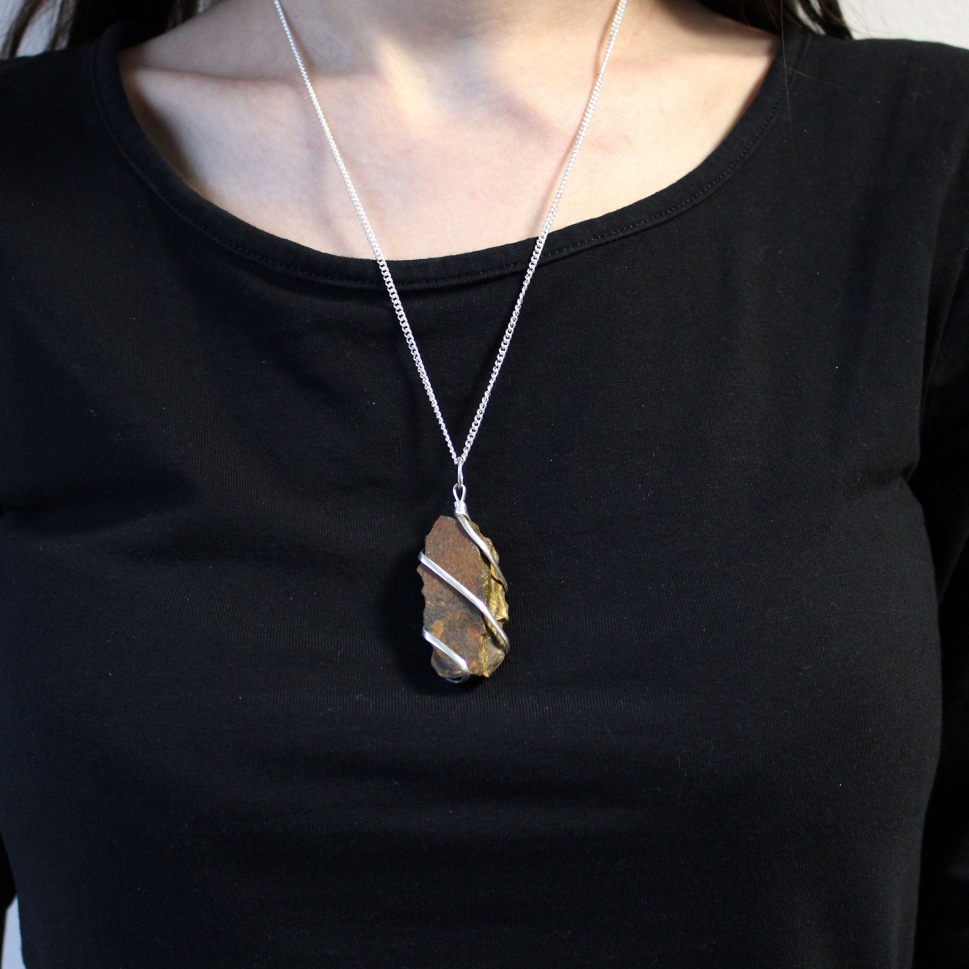 Person wearing a black shirt Cascade Wrapped Gemstone Necklace - Rough Tiger Eye