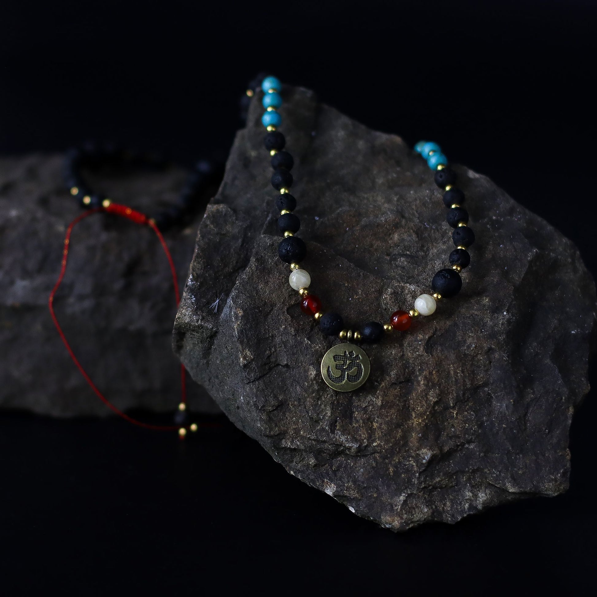 Essence of the Volcano Necklace with a pendant on a dark stone surface