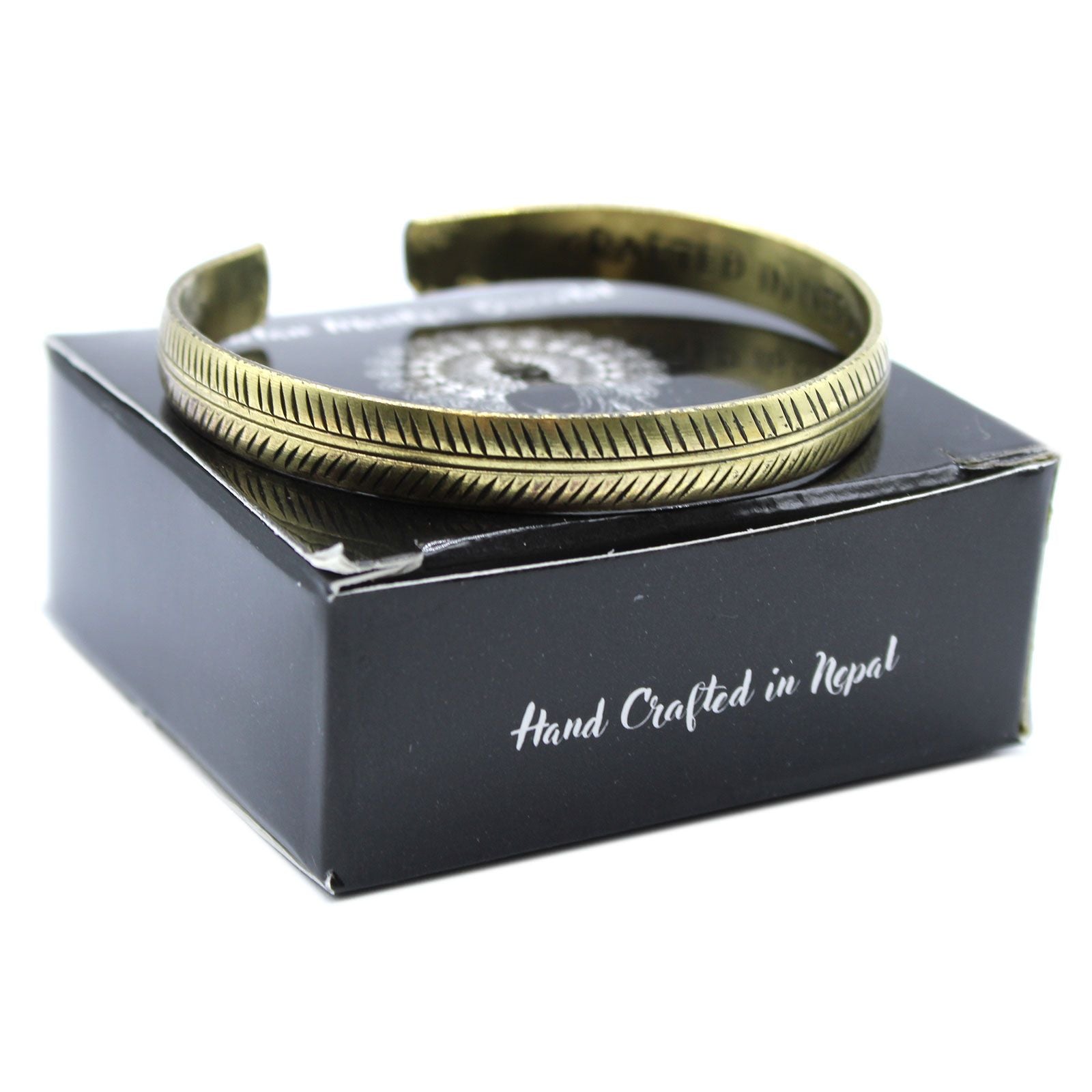 Brass Tibetan Bracelet on a black box with 'Hand Crafted in Nepal' text