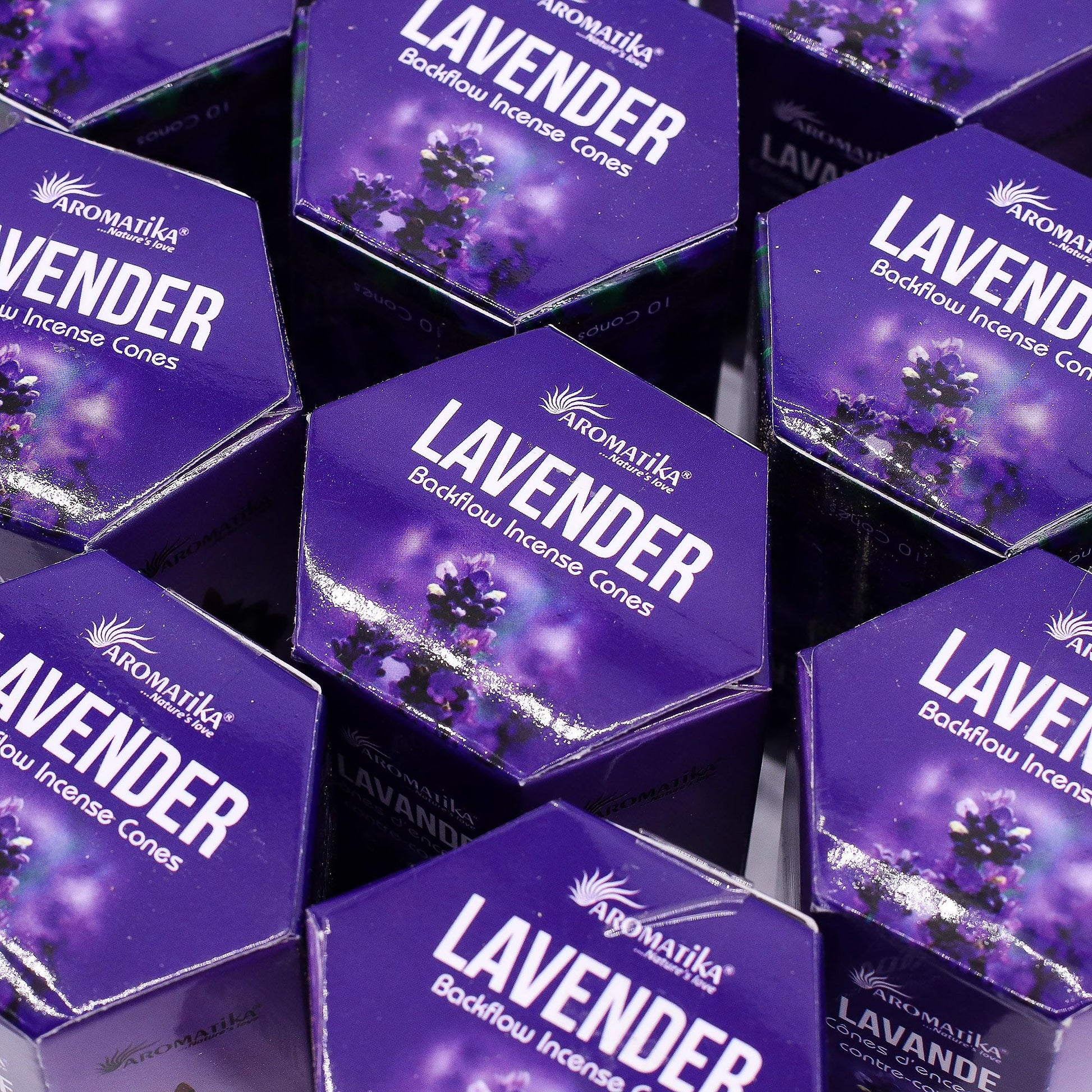 Multiple boxes of Aromatika Lavender Backflow Incense Cones on a reflective surface.