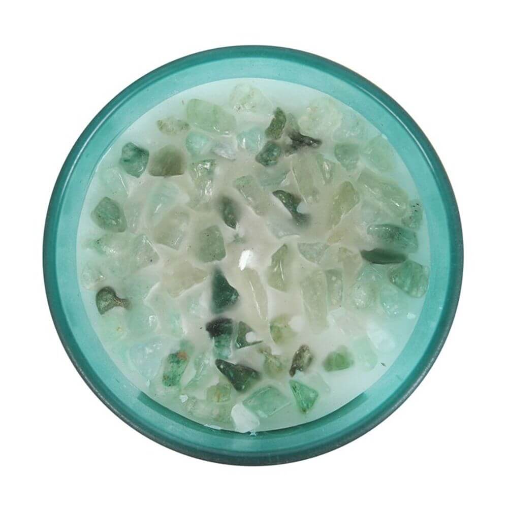 Heart chakra mint candle with green aventurine crystal chips in a frosted glass holder, ideal for spiritual rituals.
